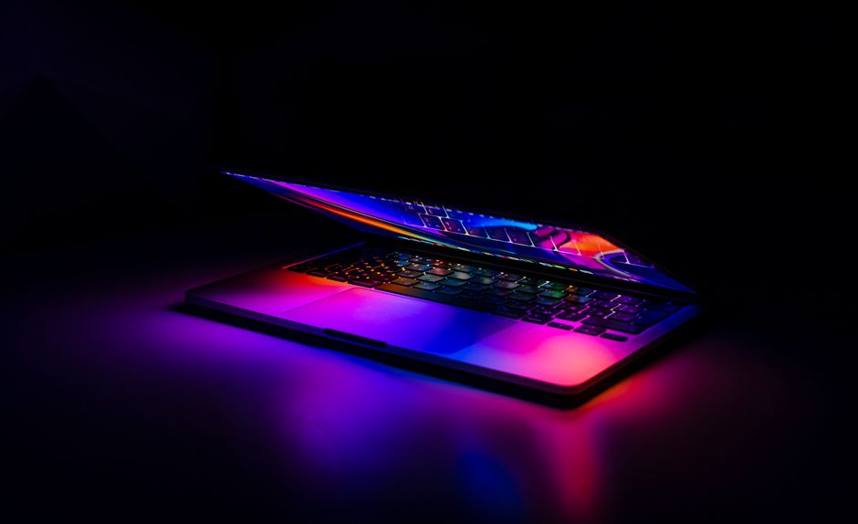 MacBook s neonskim svjetlosnim refleksijama