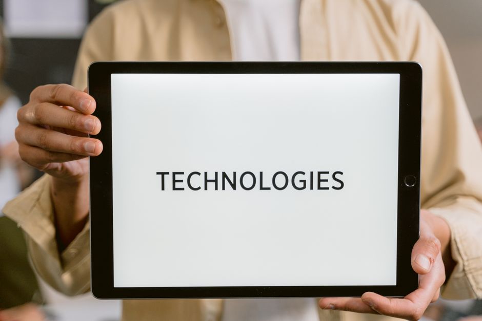 Osoba koja drži tablet s riječju Technologies na ekranu